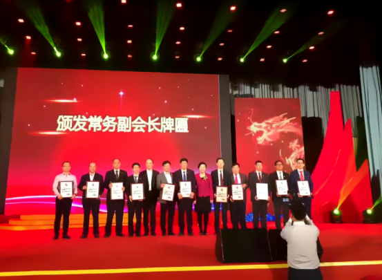 仟億達集團董事長(cháng)鄭兩斌（右1）領(lǐng)取商會(huì )常務(wù)副會(huì )長(cháng)牌匾并與福建省委常委、統戰部長(cháng)雷春美女士（右6）合影留念